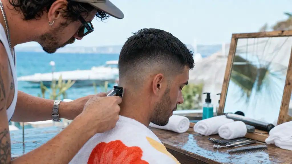 Dégradé espagnol court low mid skin fade, coiffeur règle la tondeuse sur la nuque