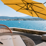 Parasol anti vent avec baleines et lestage béton sur terrasse au bord de l’eau