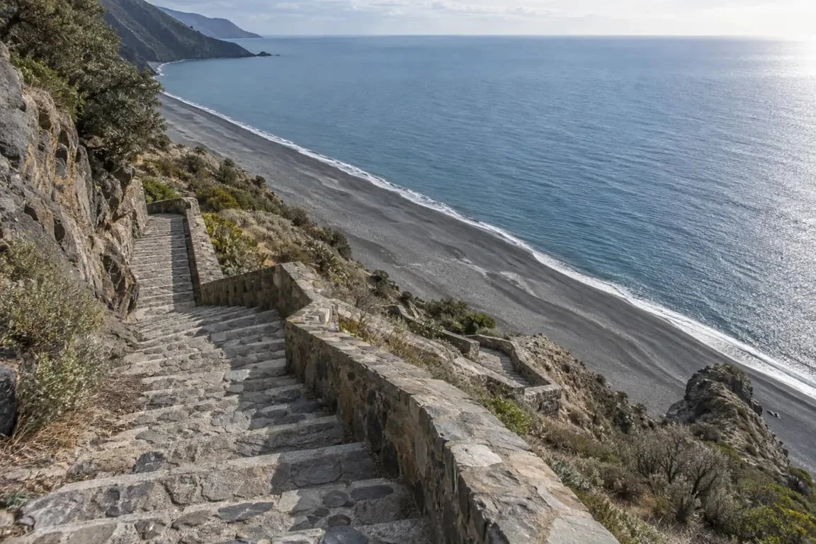 Escalier d’accès à la plage de Nonza avec vue sur le rivage noir