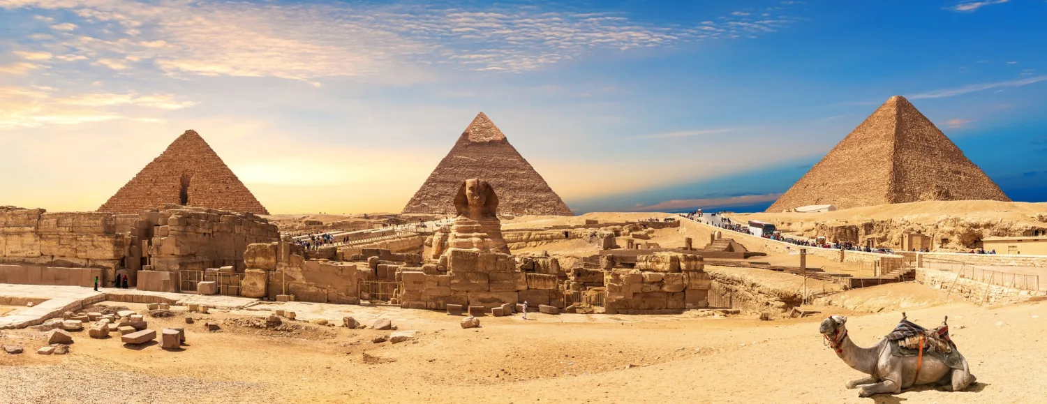 Panorama des pyramides de Gizeh et du Sphinx avec un chameau allongé